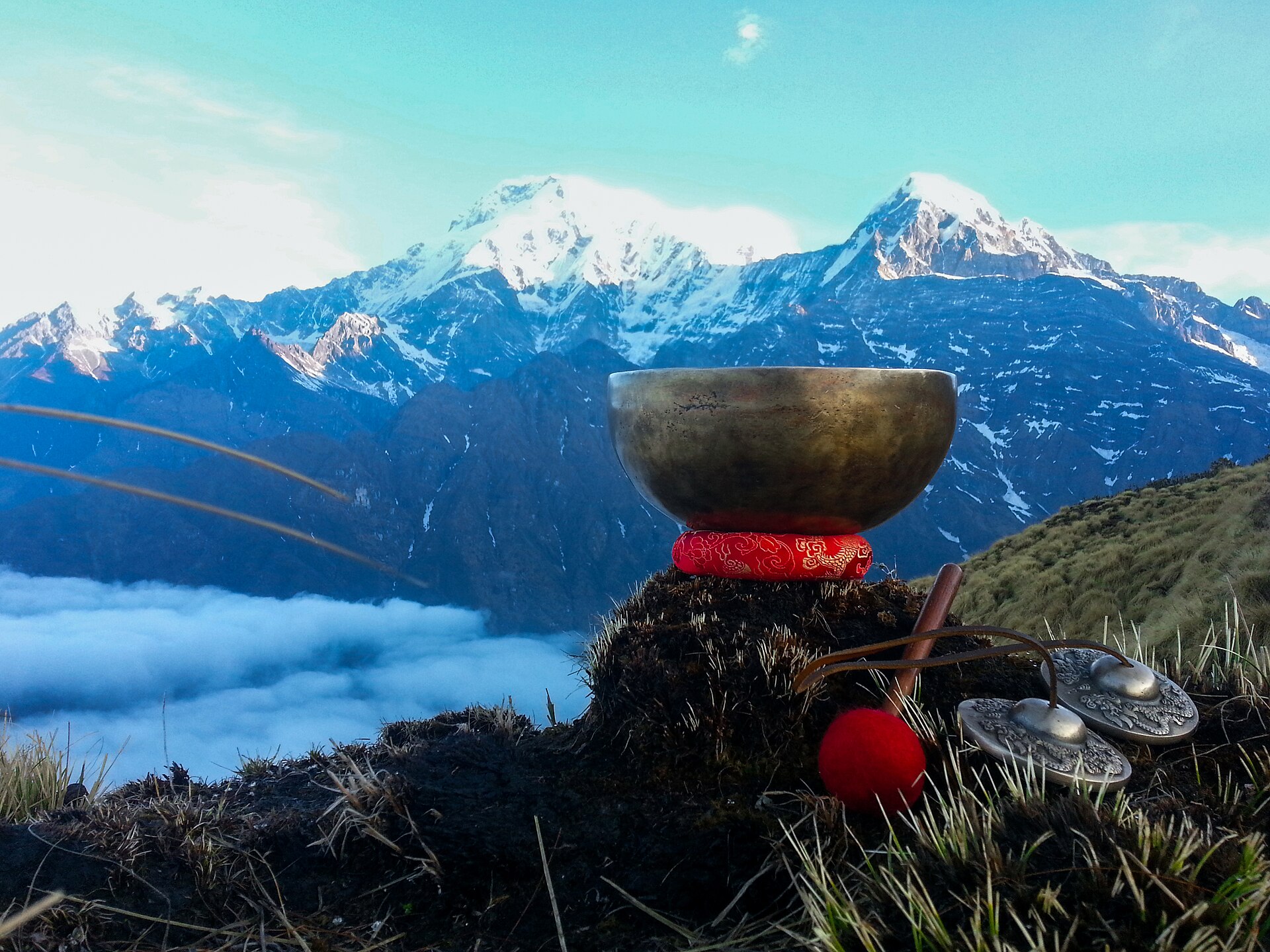 A singing bowl resting on a ridge above a sea of cloud