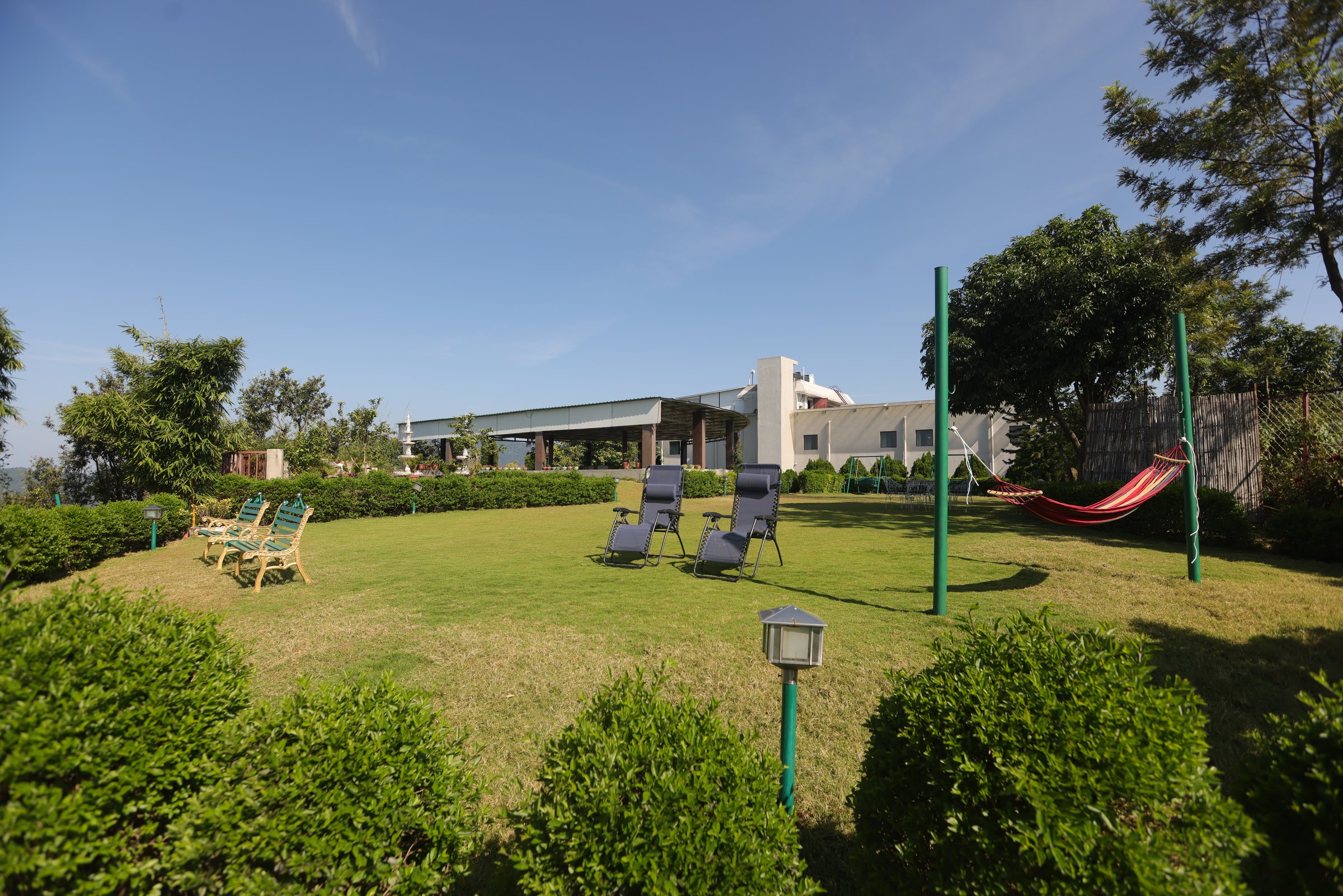 Two loungers and a hammock on the sunlit retreat lawn